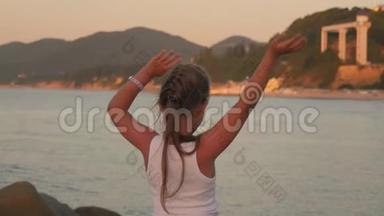 快乐的小女孩在海上<strong>张开双手</strong>享受自由。夕阳海边海滩，欢呼雀跃的女徒步旅行者<strong>张开</strong>双臂。